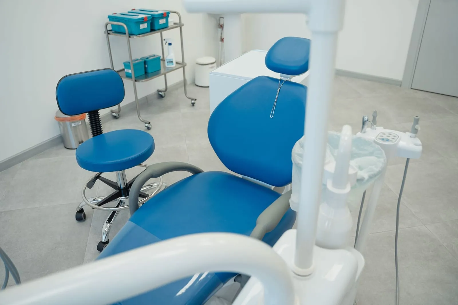 Sillón dental azul y taburete en un gabinete luminoso de la clínica